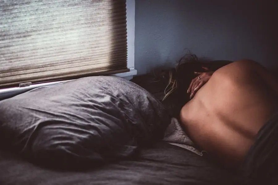 a woman lying on a bed suffering from migraines