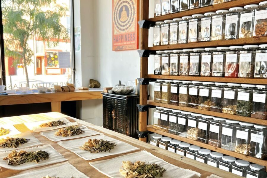 Image from our shop displaying shelves in our herbal apothecary and a table that contains herbal remedies in the process of being created